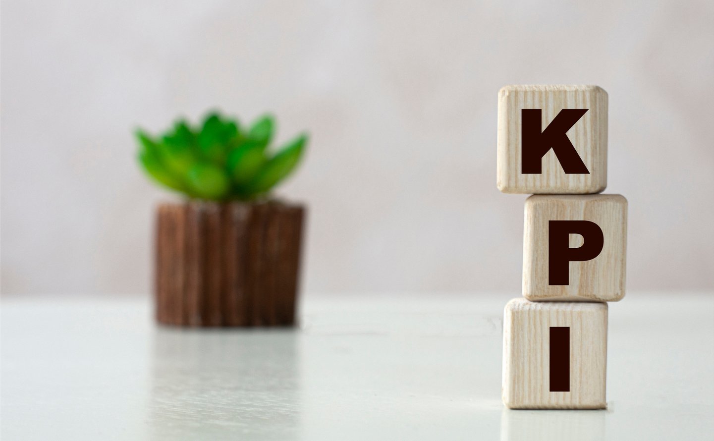 KPI word on wooden cubes on a light background with a cactus